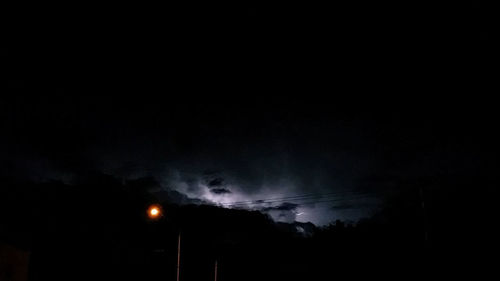 Low angle view of illuminated lights against sky at night