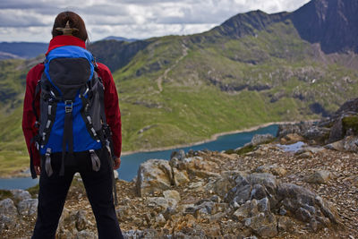 Woman with rucksack overlooking a mountain lake on snowdonia