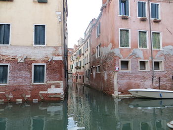 Canal amidst old buildings in city