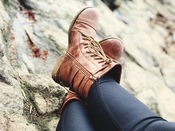 Low section of woman sitting on rock