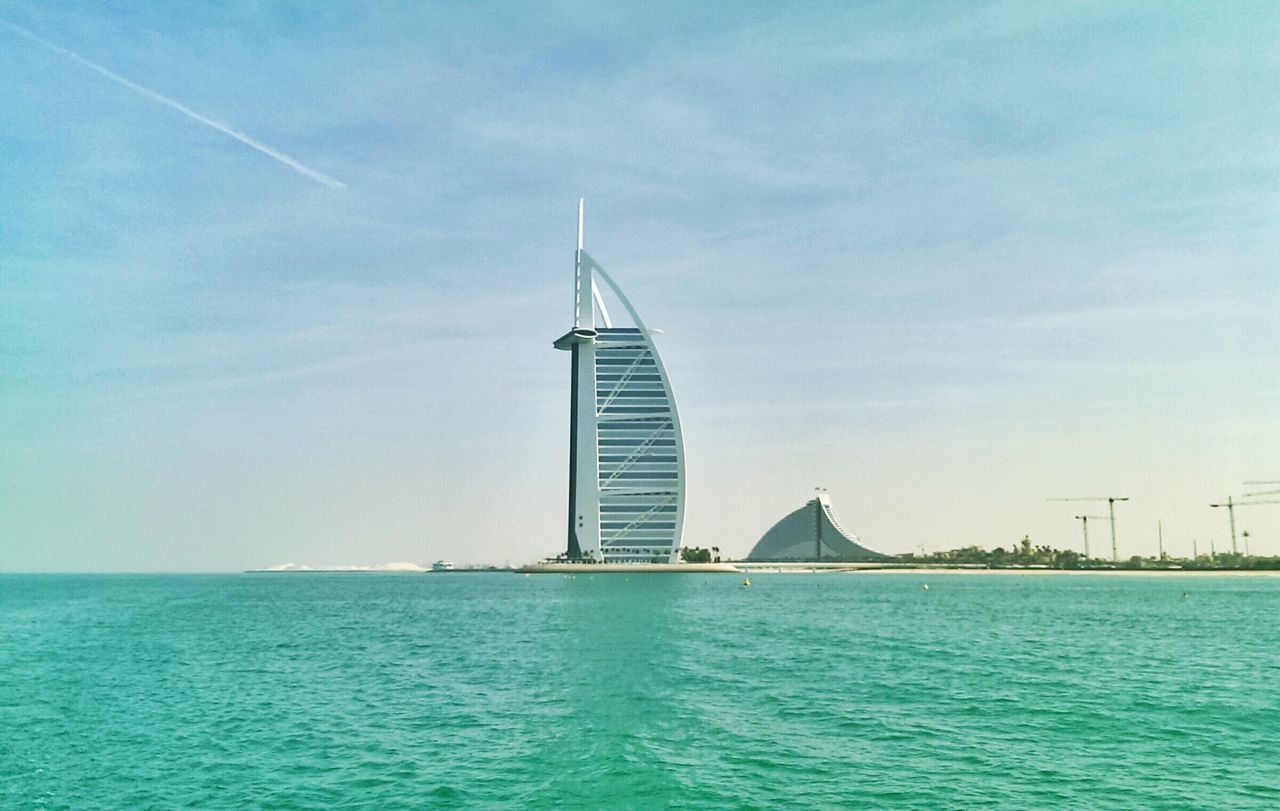 architecture, built structure, building exterior, waterfront, water, blue, sea, tower, sky, tall - high, day, city, travel destinations, travel, outdoors, clear sky, rippled, nautical vessel, modern, tourism
