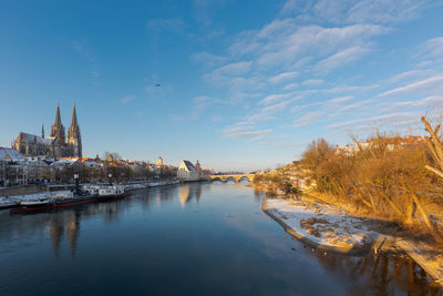 Looking down on the breakwater pillars with snow and the danube from the stone bridge in regensburg