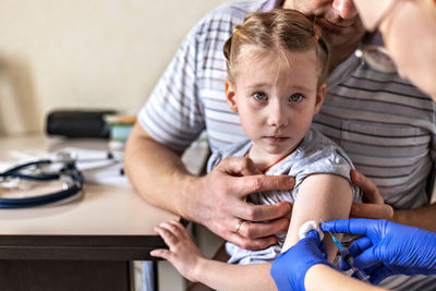 A little girl  in the doctor's office . the concept of vaccination prevention against covid-19