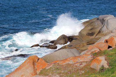 Waves breaking against rocks in sea