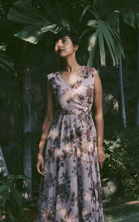 Portrait of young woman standing against plants