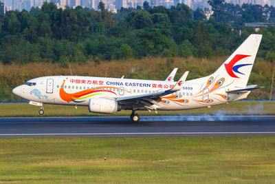 Side view of airplane on airport runway against sky