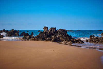 Scenic view of beach against blue sky