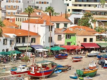 Boats moored in canal by buildings in city