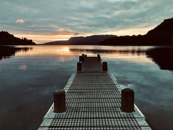 Pier on lake against sky during sunrise, lake tarawera new zealand 