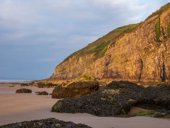 Rock formations by sea against sky