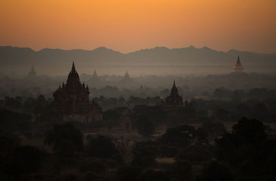 Stupas against mountains during sunset