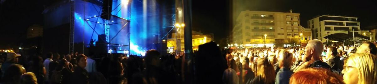 Panoramic view of crowd in city at night