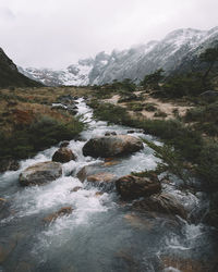 Scenic view of river and mountains against sky