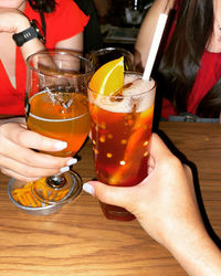 Cropped image of hand holding beer glass on table