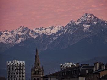 Panoramic view of buildings and mountains against sky during sunset