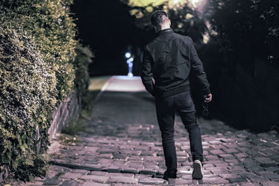 Rear view of man walking on footpath