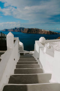 Staircase leading towards sea against sky