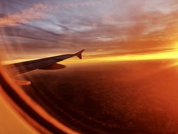 Airplane flying against sky during sunset