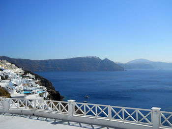 Scenic view of sea and mountains against clear blue sky