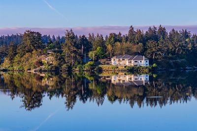 Reflection of trees in lake against clear sky