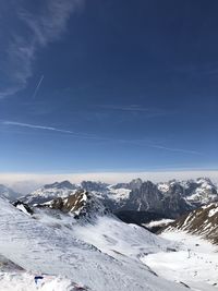 Scenic view of snowcapped mountains against blue sky