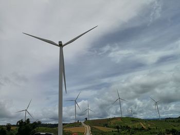 Low angle view of windmill on field against sky