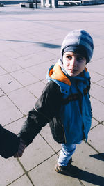 Cropped image of mother and son walking on footpath