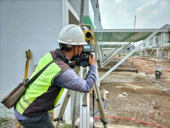 Engineer surveyor working with theodolite at housing construction site