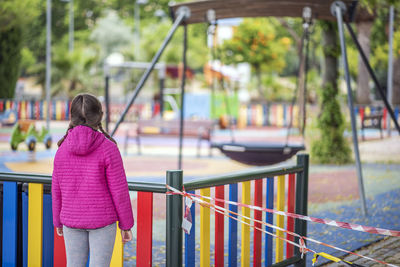 Rear view of woman standing on playground