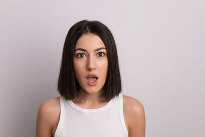 Portrait of young woman against white background