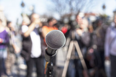 Close-up of microphone against people