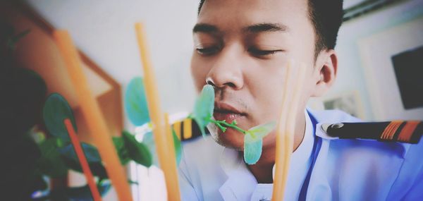 Young man smelling plant