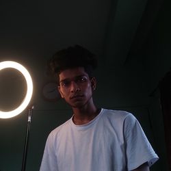 Young man standing against black background