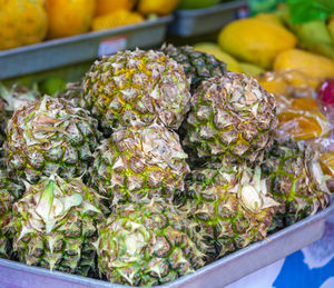 Fruit background with many fresh ripe pineapples for sale on local organic farm market