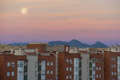 Sunrise with moon over the city