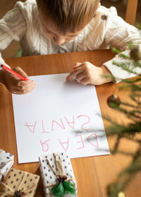 High angle view of boy drawing on paper