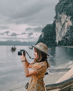 Young woman on boat in sea against sky