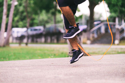 Low section of man skateboarding on road