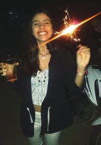 Portrait of smiling young woman standing at night