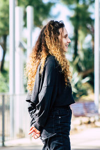 Side view of woman wearing hat standing outdoors