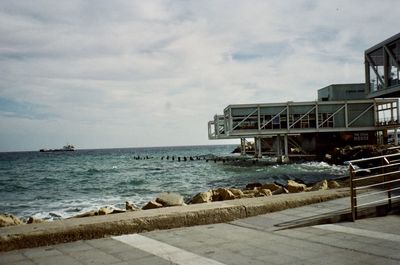 Scenic view of sea by buildings against sky