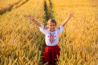 Portrait of girl standing at wheat farm