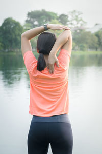 Rear view of woman standing in lake