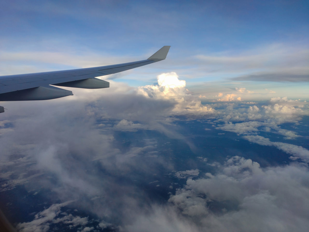 cloud, airplane, air vehicle, sky, flying, aircraft wing, transportation, aerial view, mode of transportation, travel, nature, environment, cloudscape, aircraft, air travel, mid-air, journey, vehicle, no people, scenics - nature, blue, aviation, beauty in nature, high up, outdoors, motion, day, wing, on the move, landscape, above, horizon