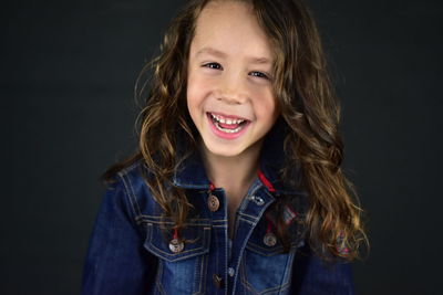 Portrait of a smiling young woman over black background