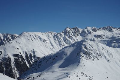 Scenic view of snowcapped mountains against clear blue sky