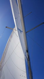 Low angle view of sailboat against clear blue sky