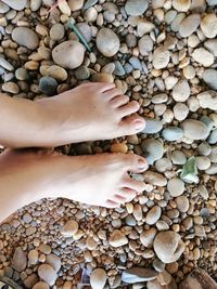 Low section of person on stone stack of pebbles