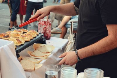 Midsection of man toasting breads at market