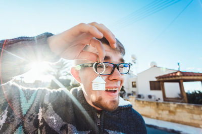 Portrait of young man with eyeglasses against sky